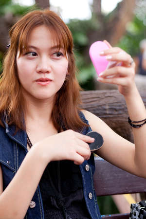 Women are the mirror to comb your hair and in the garden.の写真素材