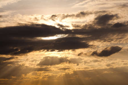 evening sky. The sun shines light through the clouds.
