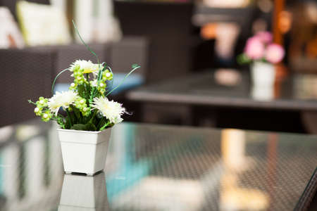 Vase of flowers placed on a table in a restaurant.