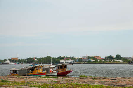 Boats moored in the river. Three ships moored in the river. There are many floating logs.の写真素材