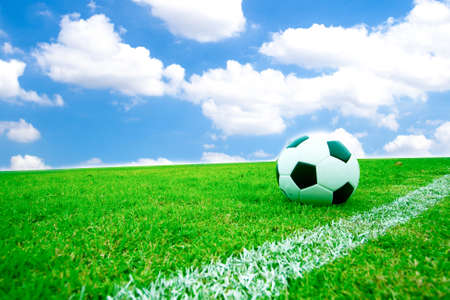 Soccer ball in grass. Behind the sky bright.の写真素材