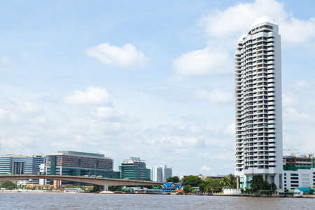Buildings along the river. The bridge over the river and harbor traffic.