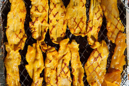 Thin rubber pig roasting on a charcoal grill.の写真素材