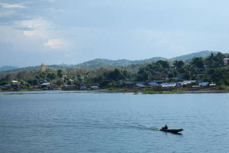 Sailing in the river. The hills behind the village adjacent to the river.の写真素材