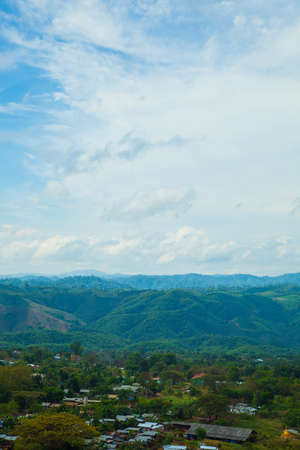 Village in the mountains. The village lies in a high valley. The sky is cloud covered.の写真素材
