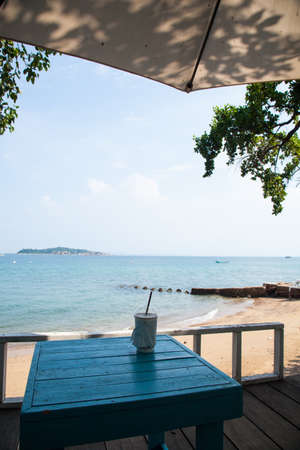 Coffee cup on the table. Beachfront restaurants at the beach.の写真素材