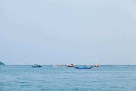Small boat moored at sea. Small fishing boats moored offshore.
