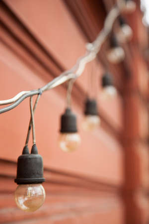 Small marks on the lamp cord in a row. Tied together with red walls.