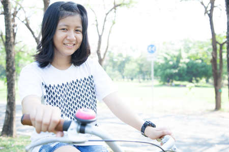 Young woman bicycling. Within the park. The space allocated for bicycling in particular.の写真素材