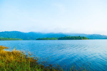 Island Lake and the mountains are covered with forests and dense fog in the morning.の写真素材