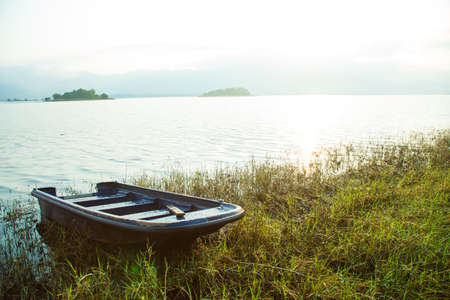 Rowing along the lake. Behind a small island. And mountains covered with fog in the morning.の写真素材