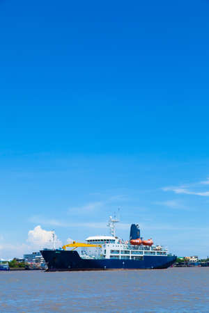 large cargo ship. Moored in the river. Space transportation industry.の写真素材