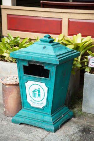 Bins made ââof wood. Green was placed on the path near the tree.の写真素材