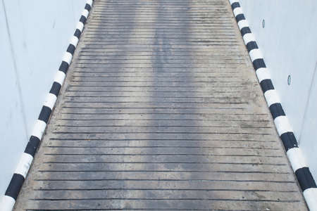 Road at the edge of the road with a sign painted in alternating black and white. Is way up from the parking lot.の写真素材