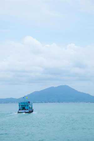 Boat sailing in the sea. Heading to the other coast with high mountains.の写真素材