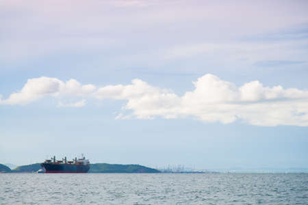 cargo ship Moored at sea. Behind the mountains. In the morning.の写真素材