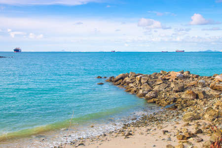 Beach rocks large Cargo ship moored in the sea side of the island.の写真素材