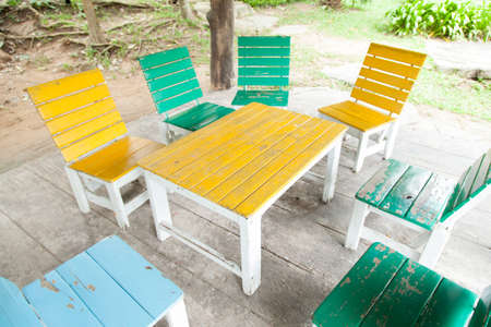 Multi-colored wooden table and chairs. Located on the floor under the pavilion.の写真素材