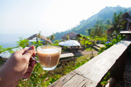 Hand holding a coffee cup To eat on the balcony in the morning.の写真素材