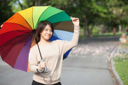 Women holding umbrella On the path in the park.の写真素材