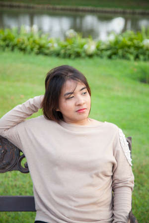 Portrait Asian woman sitting on the bench. In the parkの写真素材