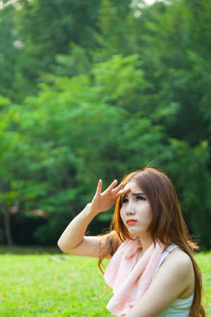 Woman is sitting a break from exercise. Sitting on the grass in the park.の写真素材