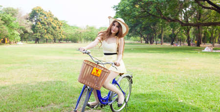 Woman riding a bicycle In the park Trees and peacefulの写真素材