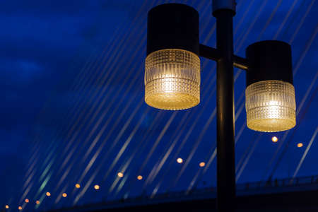 Lighting of lamps at night. In the background is the bridge over the river during the night opened fire.の写真素材