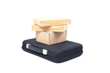 Many brown paper box on a black briefcase in studio white isolated background.の写真素材