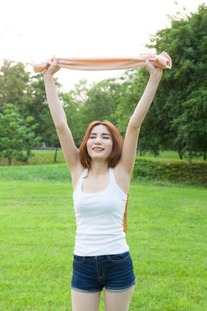 Woman warming up before exercise. on grass Within the park in the eveningの写真素材