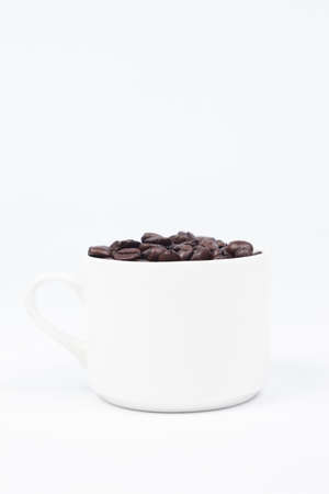 Coffee cup with coffee beans on white isolated background.