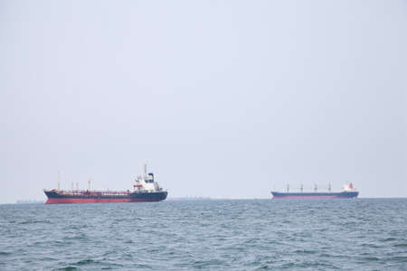 Large cargo ship Boats moored in the sea to make sense compared to the coast.の写真素材