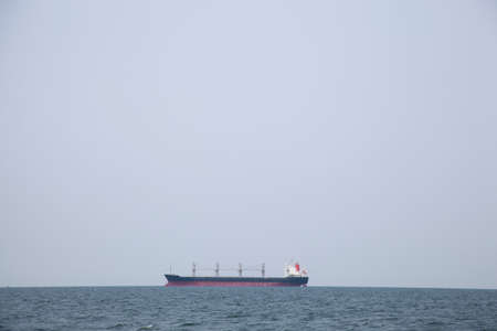 Large cargo ship Boats moored in the sea to make sense compared to the coast.の写真素材