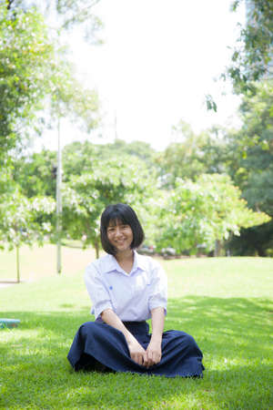 Girls relaxing on the lawn. Within the park with trees and greenery.の写真素材