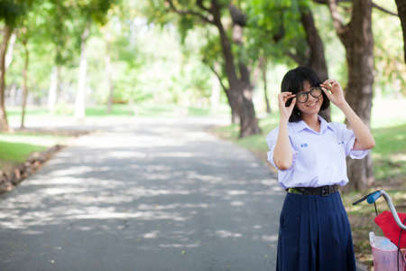 girl smile and relax Standing on the walkway in the park. There is a shady treeの写真素材