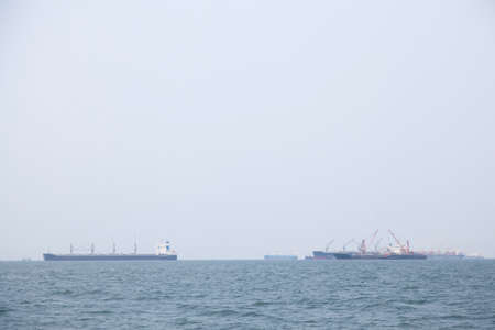 Large cargo ship Boats moored in the sea to make sense compared to the coast.