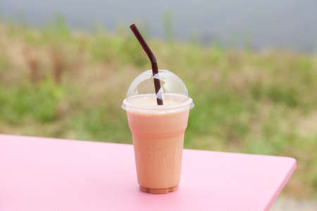 Plastic coffee mug. Coffee blended with ice in a plastic cup on the table.の写真素材