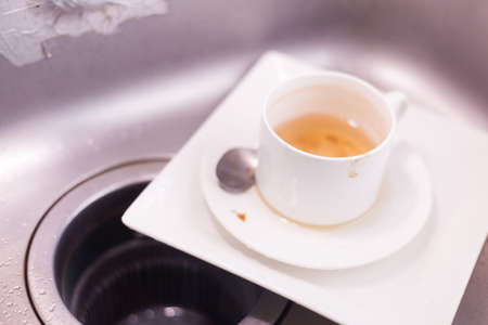 Coffee cup and white plates. Lay piled in the sink in the kitchen....の写真素材