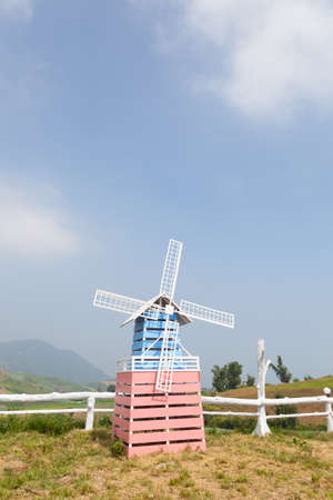 Wind turbines. Made of wood on the grass near the fence.の写真素材