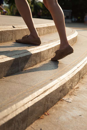 Woman moving up the ladder. Moving up the ladder that stretches to the back.の写真素材