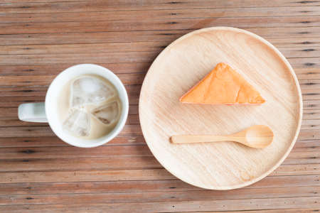 Orange cake and coffee on a wooden table. Orange cake with a spoon for eating.の写真素材