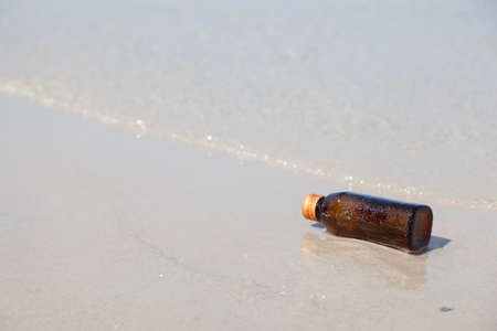 Bottle on a beach. The bottle was left sea. Pollution and environmental problems from wasteの写真素材