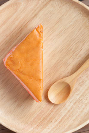 Orange cake placed in wooden plates on the table. With wooden spoonの写真素材