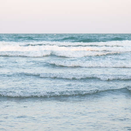 Ocean waves lapped up the beach. Crystal clear water with a little wave on a clear day.