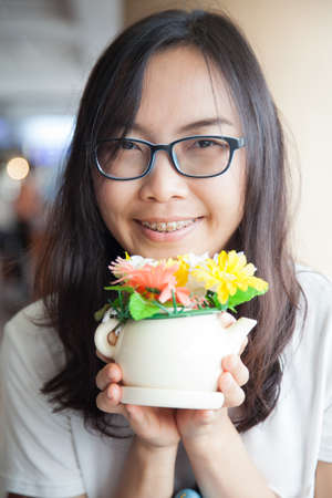 asia woman hold pot flower.joy and smile asia woman wear eyeglasses.の写真素材