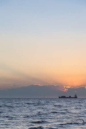 Large cargo ship In the morning the sun rises Ship moored in the seaの写真素材