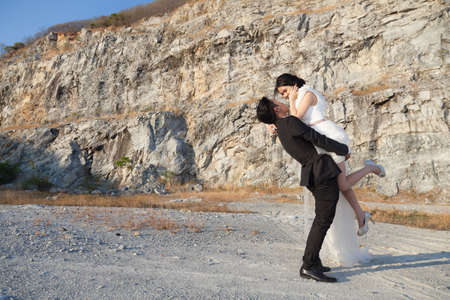 groom carries the bride. Close to the mountains and the desert heat.の写真素材
