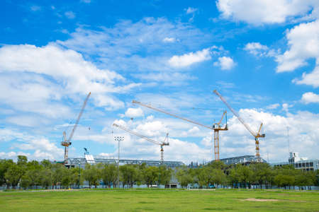 Construction cranes in construction area Large building construction The sky is clearing up.の写真素材