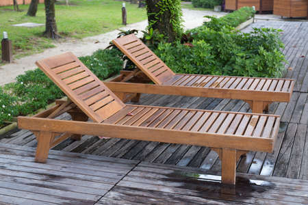 Wooden bed on the balcony. Beds made of wood under a tree on the terrace.