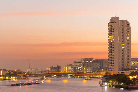 Bangkok evening and rivers General cargo ship Building high-rise buildings by the river During the evening,の写真素材